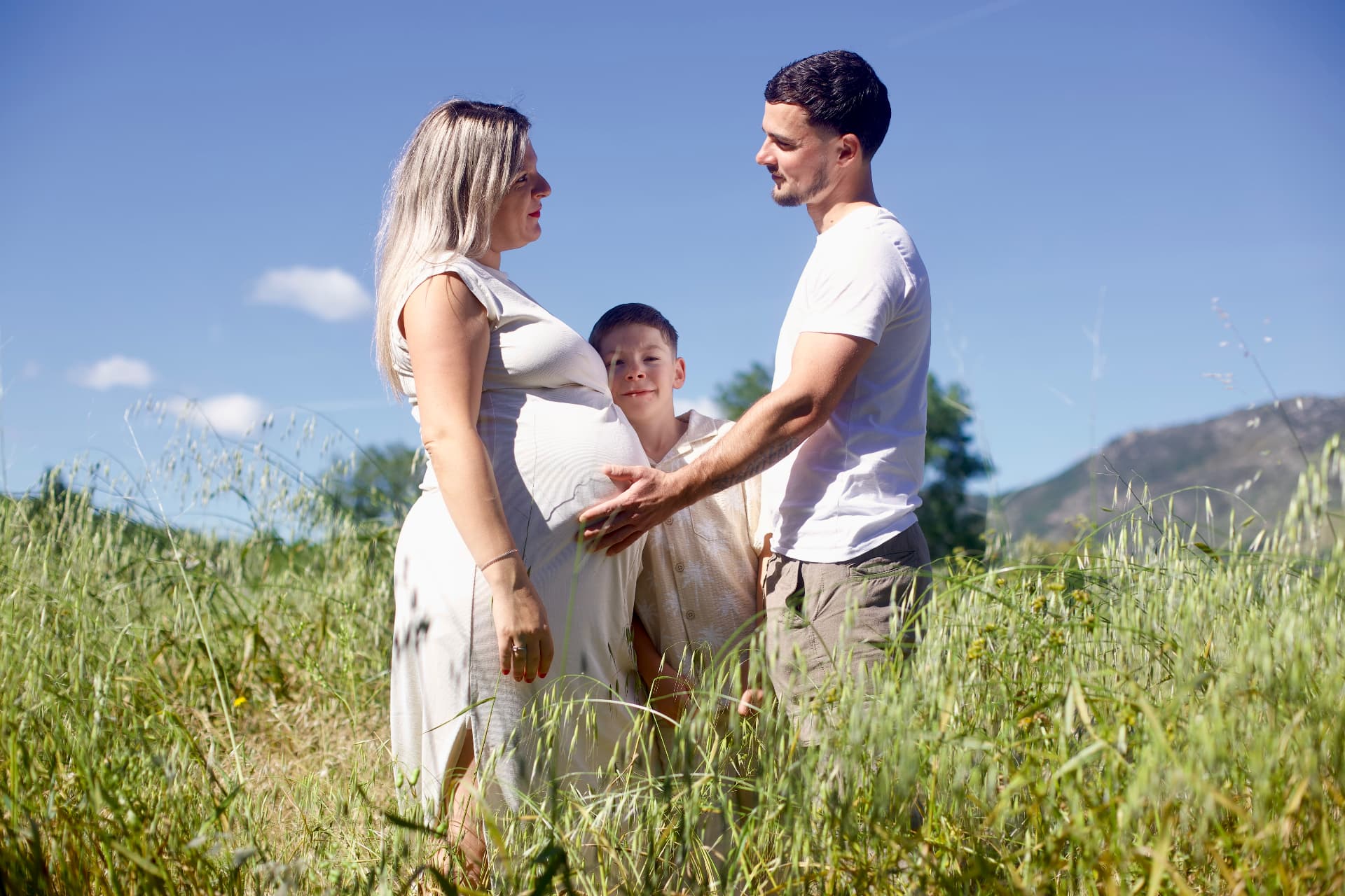 Futurs parents et leur fils dans un champ